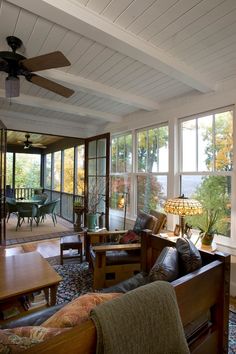 a living room filled with lots of furniture next to a window covered in glass doors