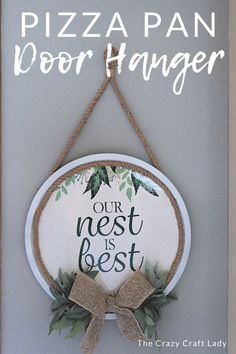 a sign that says our nest is best hanging on the wall with a bow around it