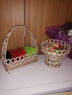 two baskets on top of a washing machine with toothbrushes and other items in them