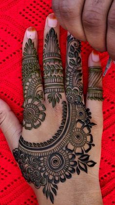 a woman's hand with henna tattoos on it