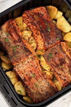 cooked fish and potatoes in a roasting pan on a marble counter top with the title above it