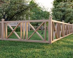 a wooden fence in the middle of some grass