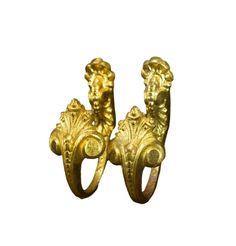 two gold rings with lions on them, one is facing the opposite direction and the other has