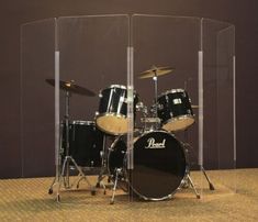 a set of drums in front of a glass case with the word pearl on it