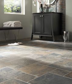 a bathroom with tile flooring and a vanity in the corner next to a window