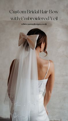 the back of a bride's dress with a bow on her head and veil