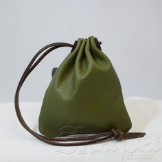 a green leather bag sitting on top of a white surface