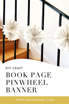 the book page pinwheel banner is hanging from a stair rail with paper stars attached to it