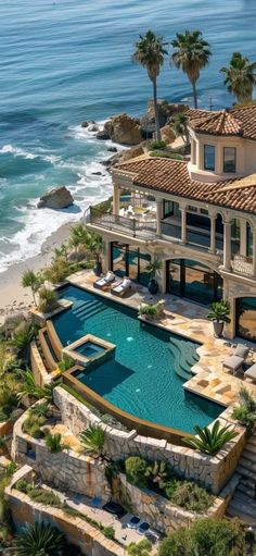 an aerial view of a house with a swimming pool and ocean in the back ground