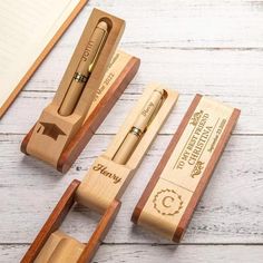 three wooden pen holders with pens in them