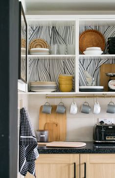 the kitchen is clean and ready for us to use it's shelves are lined with pots, pans, and mugs