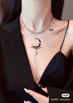 a woman wearing a necklace with the letter m on it and a crescent moon tattoo