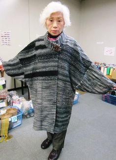 an older woman standing in front of a pile of presents