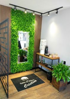 a green wall in the corner of a hair salon with plants growing on it's walls