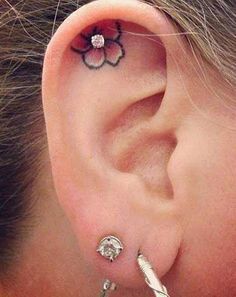 a woman with a flower tattoo on her left ear