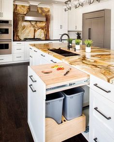 a kitchen with white cabinets and wooden counter tops