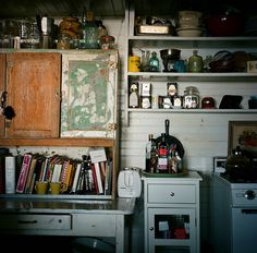 an old kitchen with lots of clutter on the shelves