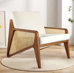 a white chair sitting on top of a wooden floor next to a potted plant