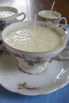 two cups filled with soup sitting on top of a saucer