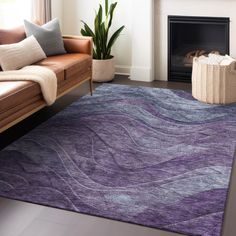 a living room with a couch, chair and rug on the floor in front of a fireplace