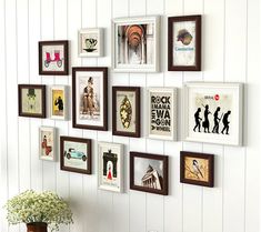 a bunch of framed pictures are hanging on the wall next to a vase with flowers