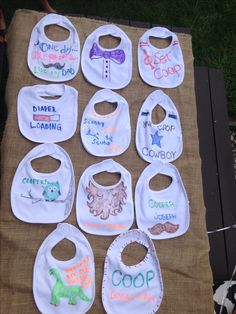 baby bibs are laid out on a picnic table with the names of their babies