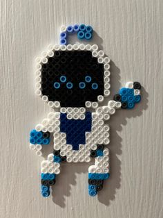 an ornament made out of legos is displayed on a white surface with blue and black beads