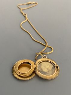 "Weight: 11.9g Dimensions: 1\" round, 18\" chain Hallmarks: Makers mark L & M Although these lockets were patented in the year 1902, this particular locket states on its backside that it is from the 'class of '12' dating it to a decade later. This is a very unique locket in that it has 3 windows and folds like an accordion. All bezels are present and the two clear windows inside the front and back covers are still present. The locket measures 1\" round and comes on an 18\" GF chain. Very lig Heirloom Locket Pendant Necklace, Vintage Oval Necklace With Coin Pendant, Antique Coin Pendant Necklace, Antique 14k Gold Pendant Locket Necklace, Vintage Oval Jewelry With Coin Pendant, Formal Round Pendant Locket Necklace Stamped 14k, Classic 14k Stamped Medallion Locket Necklace, Heirloom Yellow Gold Medallion Locket Necklace, Yellow Gold Medallion Locket Necklace Stamped 14k