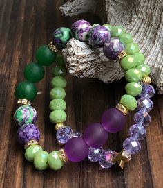 These two bracelets paired so well, we had to offer them as such! For the first Purple and Green bracelet we used four different types of beads. We started with a few 10mm  Purple Rainforest Agate beads, along with 8mm Green Crystal, 10mm Purple Frosted Glass, then completed it with 10mm Green Jade Agate beads...the results are stunning! Wear with anything!  The second bracelet in this ravishing duo to has the same 8mm Green Crystal beads paired with 8mm Purple Crystal Beads, then connected it all together with a dainty *limited edition* Star Charm. This is a lovely set, don't miss out! Price includes both bracelets.  Bead Size: 8mm, 10mm  Bead Type: Green Crystal, Purple Rainforest, Purple Frosted Glass, Purple Crystal. Beaded on a Grade-A Stretch Cord All items are packaged in a high-qua Cheap Green Bracelet, Cheap Green Wrap Bracelet As Gift, Affordable Green Crystal Bracelet With 8mm Beads, Green Friendship Bracelets With Spacer Beads As A Gift, Green Friendship Bracelets With 8mm Beads As Gift, Purple Crystal Bracelet, Purple Watch, Purple Bracelet, Beads Bracelet Design