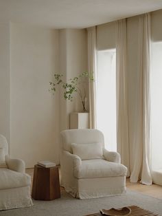 a living room with white furniture and curtains