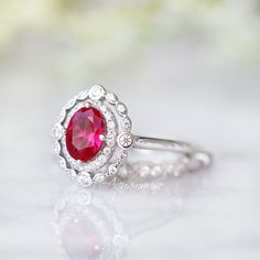 Beautiful Vintage Inspired Ruby Ring Made of Solid Sterling Silver, Rhodium Plated (925) Can be paired with one or two half-eternity Milgrain bands of your choice Accented with Simulated Diamonds (CZ) Center Stone: Ruby Grade: AAA Stone Cut: Oval Gem size: 7.0 x 5.0 mm Carat Weight: 0.76 (approx.) Gemstone creation: 100% Genuine Lab-Grown Ruby Stone Origin: Russia Handling time: 1-2 business days Free domestic shipping. Usually takes 2-5 business days. Wrapped & ready to give in a beautiful Classic Round Band Lab-created Ruby Jewelry, Classic Lab-created Ruby Round Band Jewelry, Formal Rings With Halo Design And Lab-created Ruby, Classic Ruby Halo Ring, Anniversary White Gold Ruby Ring With Halo, Classic Jewelry For Proposal With Accent Stones, Classic Proposal Jewelry With Accent Stones, Anniversary Ruby Ring With Halo Design In Cubic Zirconia, Classic Ruby Ring With Halo Setting For Promise