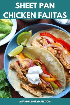 two chicken fajitas on a blue plate with limes and cilantro