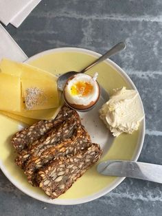 a white plate topped with granola, cheese and an egg