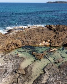 some rocks and water near the ocean