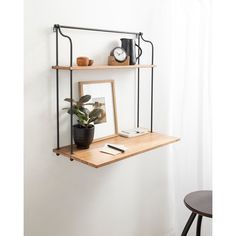 three wooden shelves with books, magazines and other items on them against a white wall