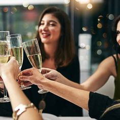 three women toasting with champagne glasses in front of them