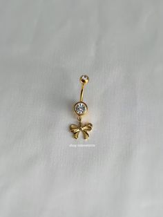 an image of a gold belly button with a bow and crystal stone in the center