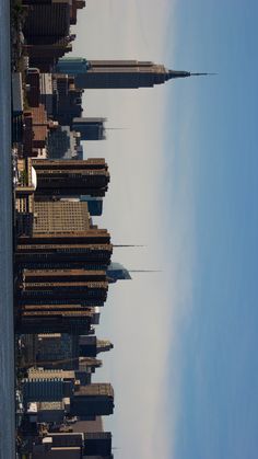 the sky is blue and white with some clouds in it as well as tall buildings