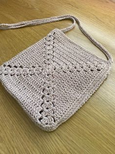 a crocheted purse sitting on top of a wooden table