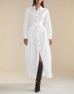 Crisp white cotton shirt dress. Classic collar Gold buttons down front Long sleeves with gold button cuff Maxi length Comfortable, relaxed fit with a cinched waist for a flattering silhouette Complete with a detachable tie belt to accentuate the waist Fabric content: 100% cotton Care instructions: dry clean recommended, machine wash cold, hang dry Fit: model is 5'9" and wears a size S. Size small measurements: Length from shoulder: 48" Final Sale Shirt Dress White, White Belted Shirt Dress For Work, Elegant Cotton Shirt Dress With Belted Cuffs, Classic White Shirt Dress For Fall, White Shirt Dress With Button Cuffs For Daywear, White V-neck Shirt Dress With Buttons, White A-line Shirt Dress With Buttons, White Shirt Dress With Buttons, Mini Length, White Feminine Button-up Shirt Dress