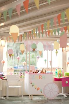 an ice cream cart is decorated with bunting and paper garlands in pastel colors