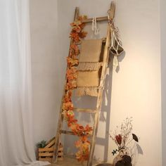 an old wooden ladder sitting on top of a table next to a vase filled with flowers