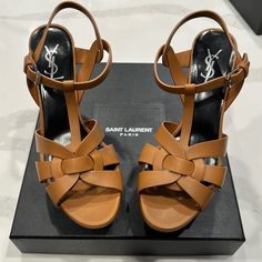 These Saint Laurent Tribute Sandals Are Characterised By A Vertiginous Stiletto Heel And Platform Sole, Rendered In Chestnut-Brown Leather. The Design's Signature Interwoven-Strap Front Is Connected With A Central T-Bar Strap And Secured With A Gold-Tone Buckle Fastening. Comes With Box And Dustbag. No Trades. Thanks Highlights * Caramel Color * Leather * Crossover Strap Detail * Open Toe * Buckle-Fastening Ankle Strap * Branded Leather Insole * Platform Sole * 4 Inch High Stiletto Heel Composit Highlights Caramel, Yves Saint Laurent Shoes, Leather Platform Sandals, Chestnut Brown, Caramel Color, Stiletto Heel, Platform Sandals, Chestnut, Crossover