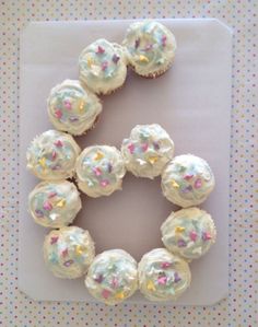 cupcakes with white frosting and sprinkles arranged in a circle