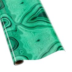 a roll of green marble paper on a white background with an image of swirls