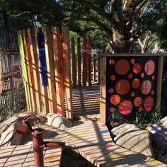 an outdoor play area with wooden fences and colorful artwork