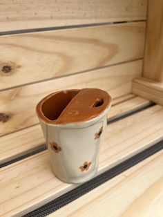 a cup sitting on top of a wooden bench