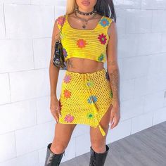 a woman in yellow outfit standing next to a white wall with her hands on her hips