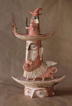 a ceramic sculpture of a man with a hat on his head and holding a pipe