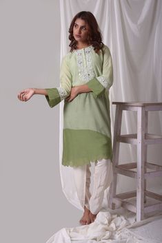 Beautiful sage green cotton silk suit is a stunning choice for weddings and festive occasions! The suit is crafted with fine simple white design work. Kurta has 3/4 length sleeves which has dark green border with white design. Kurta has multi color light green on top and dark green on bottom. It has a complementing white color dhoti. The suits simplicity gives it a unique and lovely look. Buy online from Pure Elegance. Disclaimer: The actual product may vary slightly from the image. These are custom orders, hence expect slight variation in color, placement of the motif or buta. ESTIMATED DELIVERYBecause this is a custom order, it would take about 4 weeks from the date of purchase. RETURN POLICYThis product is a custom order and cannot be returned or exchanged. Green Cotton Kurta For Wedding, Green Lawn Suit With Chikankari Embroidery, Green Cotton Silk Kurta With Chikankari Embroidery, Green Long Sleeve Cotton Silk Salwar Kameez, Semi-stitched Pista Green Raw Silk Unstitched Suit, Green Semi-stitched Dola Silk Sets, Semi-stitched Pista Green Cotton Silk Suit, Pista Green Semi-stitched Slub Silk Salwar Kameez, Semi-stitched Green Dola Silk Kurta